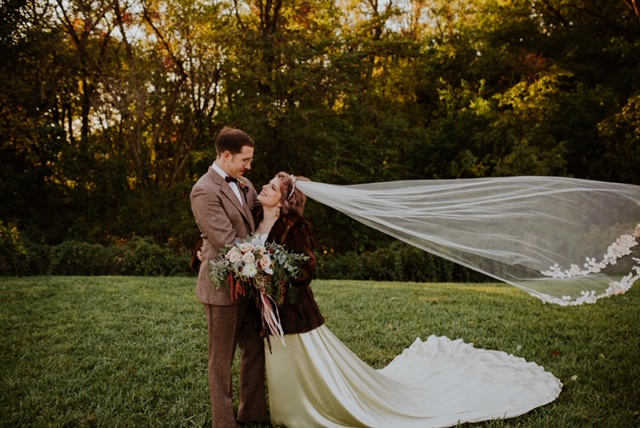 Bride and groom vintage dress with veil in wind